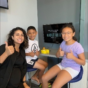 Dental team member and young dentistry patients in dental office waiting room