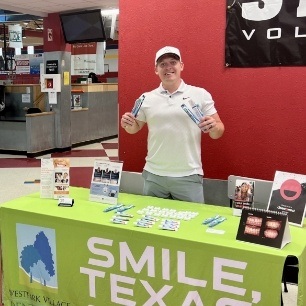 Dentist behind Smile Texas booth at community event
