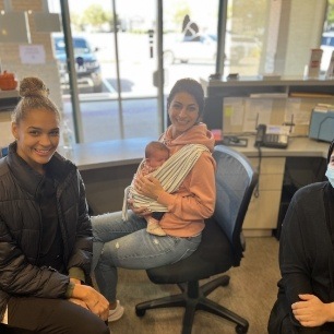 Two adult dental patients and infant in dental office