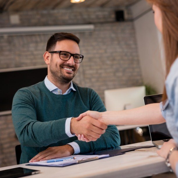 Man shaking hands with dental team member