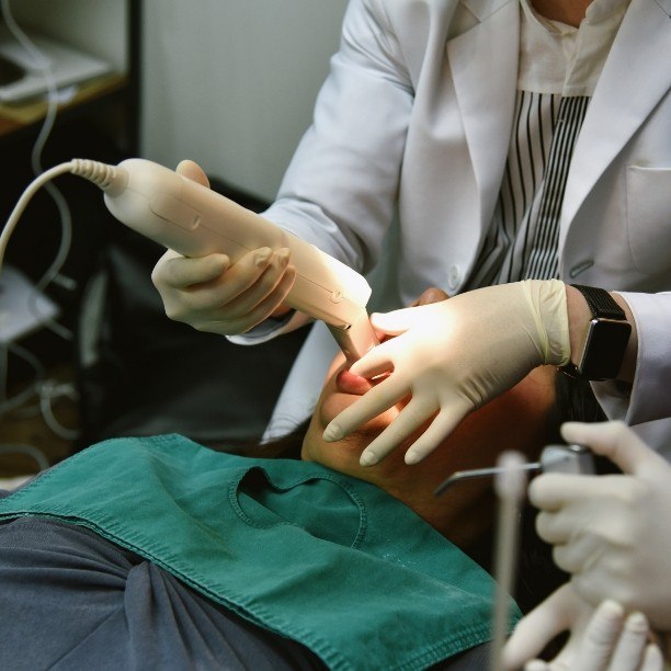 Dentist capturing digital impressions of dental patient's smile