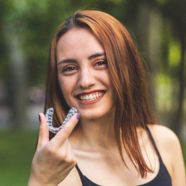 Smiling woman holding an ClearCorrect  tray