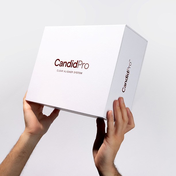 hands holding up a CandidPro Clear Aligner System box