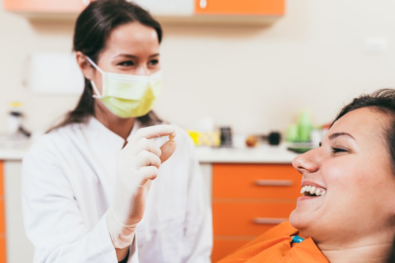 A dentist showing a patient her tooth after extraction