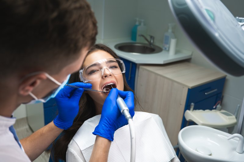A dentist performing a root canal on a young woman