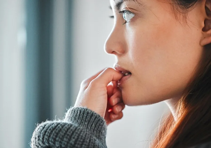 A woman nervously biting her nails